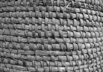 Old hand crafted basket made from dry grass in black and white.