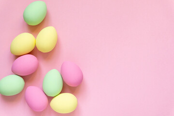 Fototapeta na wymiar Easter flat lay. Eggs painted in pastel colors on pink background, space for text
