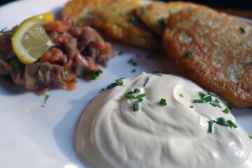 Potato pancakes with salmon and sour cream.