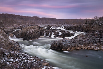 A Winter morning sunrise at Great Falls Park with the rocks covered in a dusting of snow.