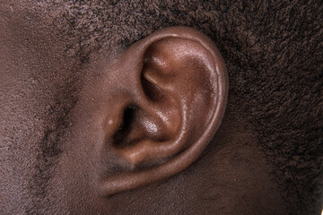 Black man ear close up. African american ear lobe. Hear and listen concept. - obrazy, fototapety, plakaty