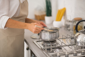 Woman in apron cooking in the kitchen