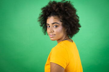 Fototapeta na wymiar African american woman wearing orange casual shirt over green background with a happy face standing and smiling with a confident smile showing teeth