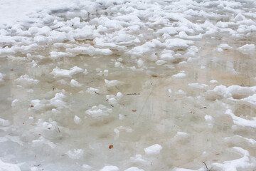 Fototapeta na wymiar Honing years. Spring thaw puddles on the road