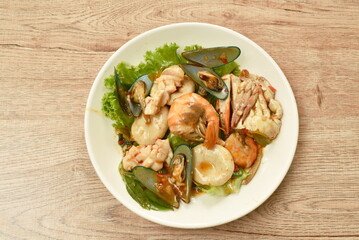 spicy chili fried squid with shrimp couple crab and fresh pepper topping basil leaf on plate