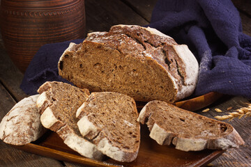 Freshly baked rye round bread from alternative flour cut into pieces, lying on the kitchen Board. Homemade cake. The fermentation process. Slow baking.