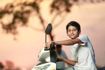Cute indian little child sitting on scooter and giving multiple expression