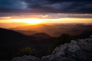Golden light fills the horizon as the sun breaks below the cloud deck at sunset in Shenandoah National Park on a spring evening.