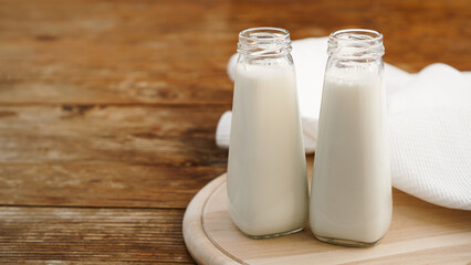 Fresh milk in two glass bottles. Wood rustic background