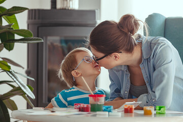 Mother or and child kiss and paint watercolor together at home