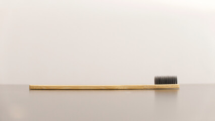 Environmentally friendly toothbrush made of bamboo against neutral background