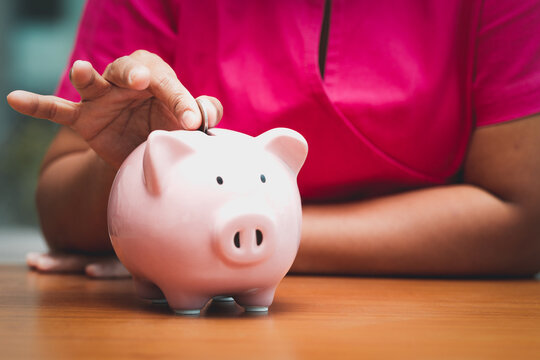 Concept business woman hand putting money coin into piggy bank saving money for future plan and retirement fund,  Saving money show putting coin and investment money for prepare  financial management.