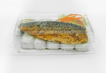 Japannese food ready-to-eat, Saba fish grilled with teriyaki sauce white rice in a cleared plastic box for sale on street food of Thailand, close up image food in box on white background.