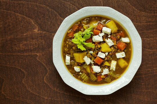 Homemade soup with various ingredients: urid dal gota and brown lentils, freekeh cereal and vegetables. Flat lay.