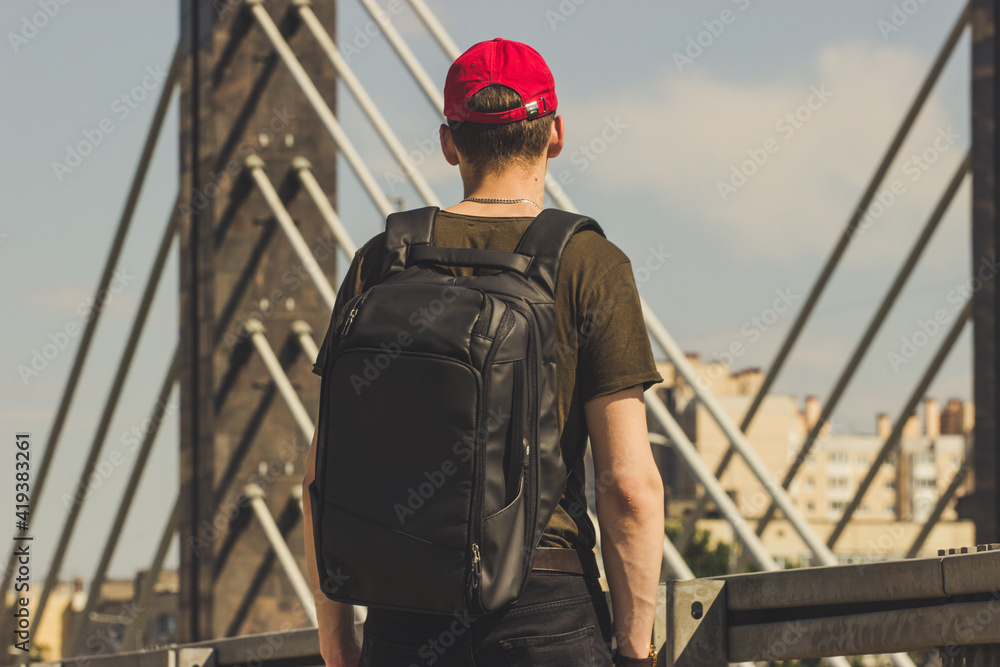 Wall mural person walking on the bridge with the backpack