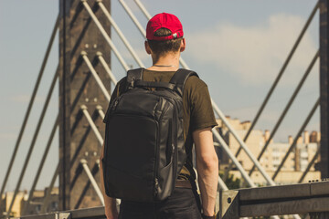 person walking on the bridge with the backpack