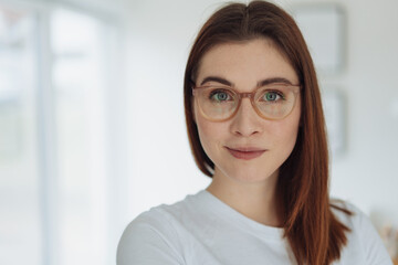 Pretty young woman with large grey eyes wearing glasses
