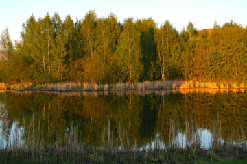Autumn landscape by the water at sunset