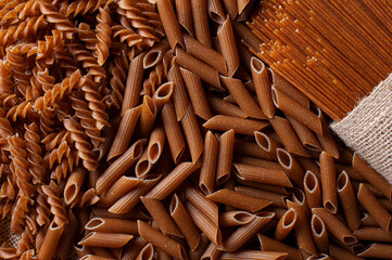 .Raw wholemeal pasta, spaghetti, penne and fusilli. Top view
