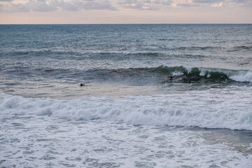 surfers waiting for the wave at Son Bunyola beach, Port des Canonge, Banyalbufar, Mallorca, Spain