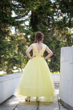 Vertical Shot Of A Beautiful Young Woman With A Yellow Wedding Dress Looking At The Green Treesâ€¤