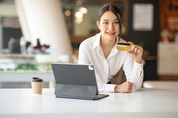 Portrait of Young woman working with tablet smartphone and credit card at home office,paying,payment,buying and online shopping concept.