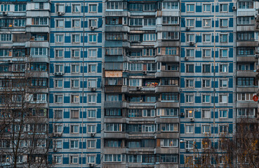 Old facades of brutalist soviet socialist buildings. The gloomy windows of Russian flats.