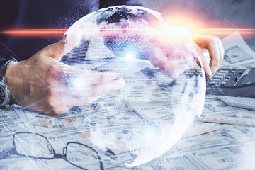 Double exposure of man's hands holding and using a phone and international business theme drawing.