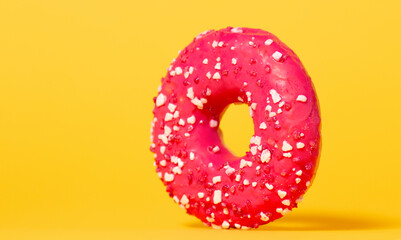 Donut with colorful sprinkles isolated on colored studio background. Round cake with hole, concept holiday fun, tasty food