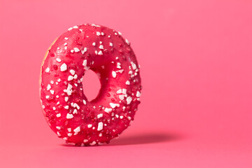 Donut with colorful sprinkles isolated on colored studio background. Round cake with hole, concept holiday fun, tasty food