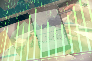 Double exposure of man's hands holding and using a phone and financial chart drawing. Market analysis concept.