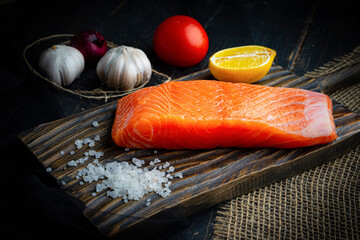 Fresh raw chilled salmon fillet on a woodencutting board. Healthy eating, seafood recipe ingredient.