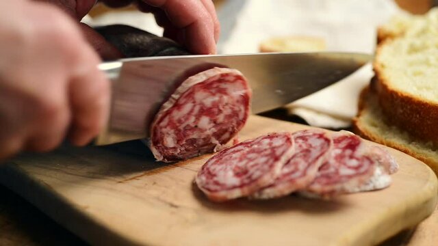 Salami sliced on wooden cutting board
