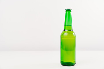 green glass bottle on a white background. condensate