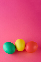 Vertical banner with green, yellow and red eggs on pink background. Happy Easter.
