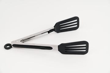 black Kitchen tongs on a white background.