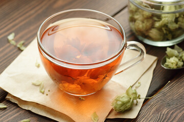 Hop herbal tea with dry herb on wooden table, natural decoction is used against insomnia,...