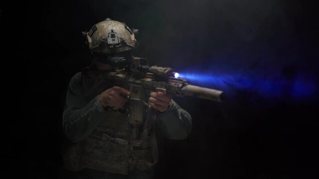 US Special forces soldier aiming with rifle at night in darkness