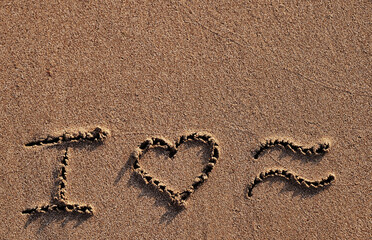 symbols i love sea written on sand