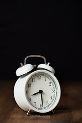 Retro alarm clock on wooden background. back to work and school concept.