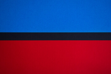 Red and blue colored paper background horizontally divided with black stripe