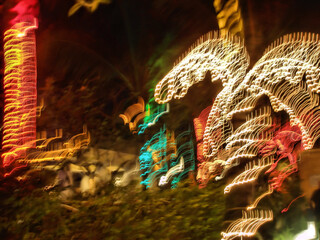 Motion night view of palm trees with  sparkling garlands