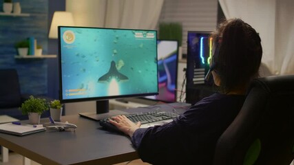 Pro gamer talking into microphone with other gamers during digital championship. Player wearing headphones and playing online video games with new graphics on powerful computer from gaming room