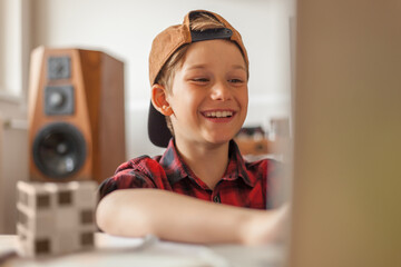Happy little boy watching something on the Internet over a computer at home.