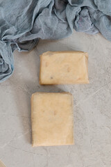 Homemade fresh cheese on gray concrete background, top view.