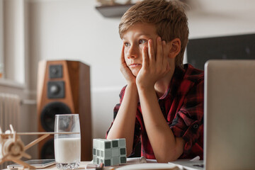 Cute little boy day dreaming in the living room.