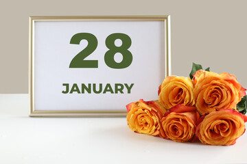 day of the month 28 January calendre photo frame and yellow rose on a white table