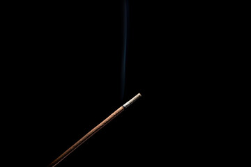 incense burner with smoke on black background.