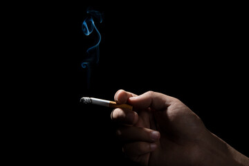 A Cropped of man hand holding cigarette black background