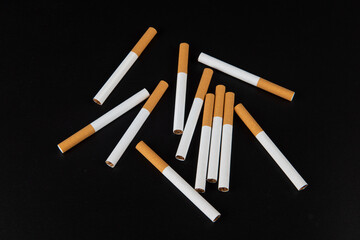 Group of cigarettes lying isolated on black background